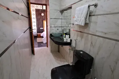 a bathroom with a black toilet and a sink at Cozy, sunny apartment near the airport in Marrakech