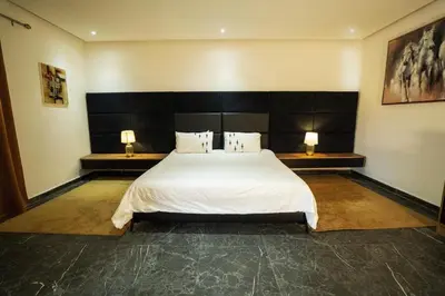 a bedroom with a large white bed with two lamps at Villa Bonsai Marrakech in Marrakech