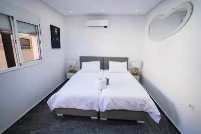 a bedroom with a large white bed with a window at Villa Bonsai Marrakech in Marrakech
