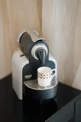 a coffee maker with a cup on a table at Appartement Cosy avec Parc et Piscine pour femme in Marrakech