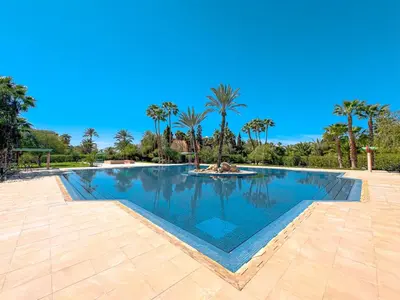 a large swimming pool with palm trees in the background at Modern Apartment in a Resort Luxury and Comfort in Marrakech