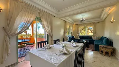 a dining room with a table and a couch at Modern Apartment in a Resort Luxury and Comfort in Marrakech