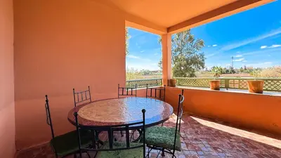 a porch with a table and chairs on a balcony at Modern Apartment in a Resort Luxury and Comfort in Marrakech