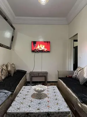 a living room with a couch and a fire painting on the wall at Palm Residence in Marrakech