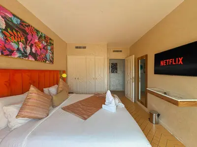 a bedroom with a large white bed with a television on the wall at Luxurious Duplex in a Peaceful Resort in Marrakech in Marrakech