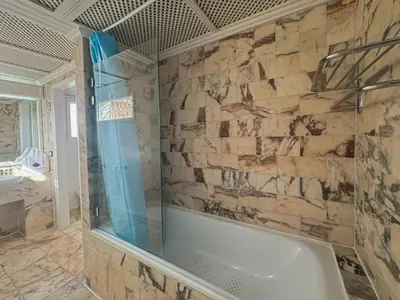 a bathroom with a tub and a stone wall at Luxurious Duplex in a Peaceful Resort in Marrakech in Marrakech