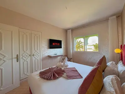 a bedroom with a bed with a clock on the wall at Luxurious Duplex in a Peaceful Resort in Marrakech in Marrakech