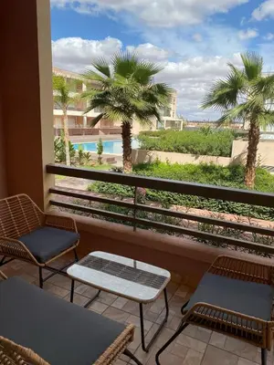 a balcony with chairs and a view of a pool at Riad Garden 1 in Marrakech