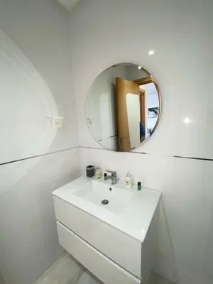 a white bathroom with a sink and a mirror at Riad Garden 1 in Marrakech