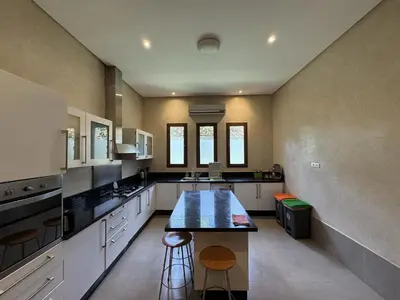 a large kitchen with a island in the middle at Villa Hilin - Piscine chauffée et hammam privé proche des golfs et du centre ville in Marrakech
