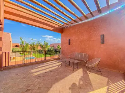 a patio with a table and chairs on a balcony at Villa Warda Luxe & Confort in Marrakech