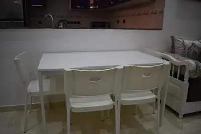 a kitchen with a white table and some chairs at Apartment A Zaitone G19 in Marrakech