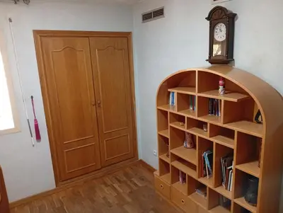 a room with a book shelf and a clock at Appartement de luxe Résidence Majorelle in Marrakech