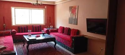 a living room with a red couch and a tv at Appartement de luxe Résidence Majorelle in Marrakech