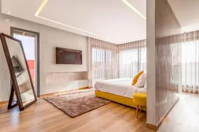 a bedroom with a bed and a tv on a wall at Villa Esma in Marrakech