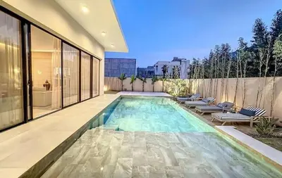 a swimming pool with lounge chairs and a house at Luxueuse Villa 5 suites Golf de Noria in Marrakech