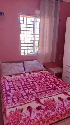 a bedroom with a bed with a pink bedspread and a window at Saada 15 marrakech in Marrakech