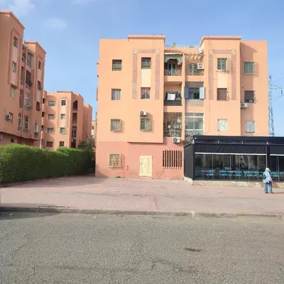 a person walking in front of a tall building at Saada 15 marrakech in Marrakech
