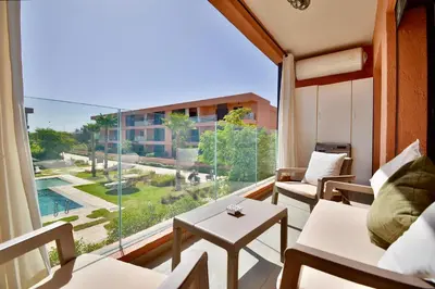 a room with a large window with a couch and a table at Appartement Domaine de Noria 7 in Marrakech