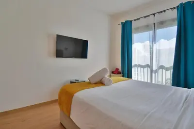 a bedroom with a bed with a tv and a window at Appartement Domaine de Noria 7 in Marrakech