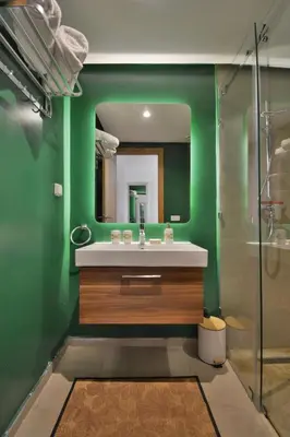 a green bathroom with a sink and a mirror at Appartement Domaine de Noria 7 in Marrakech
