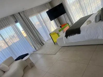 a bedroom with a bed and a couch and windows at Villa luxe kech in Marrakech