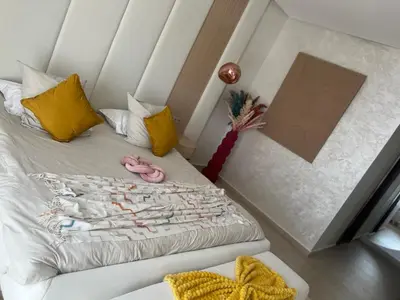 a bedroom with a white bed with yellow pillows at Villa luxe kech in Marrakech