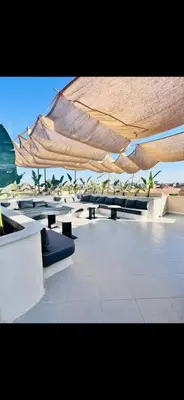 a group of picnic tables under a large umbrella at Villa luxe kech in Marrakech