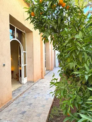 an entrance to a building with an orange tree at Palais Bohemia in El Rhechat