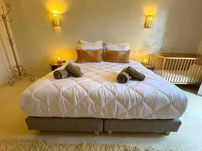 a bedroom with a large white bed with two pillows at Palais Bohemia in El Rhechat