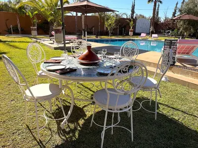 a table and chairs in front of a pool at Palais Bohemia in El Rhechat