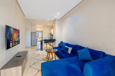 a living room with a blue couch and a table at Brand New and Stylish appart hotel Best location in Marrakech