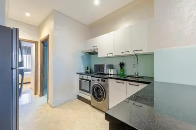 a kitchen with a stove and a washer and dryer at Brand New and Stylish appart hotel Best location in Marrakech