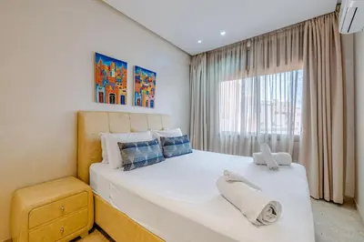 a bedroom with a large bed and a window at Brand New and Stylish appart hotel Best location in Marrakech