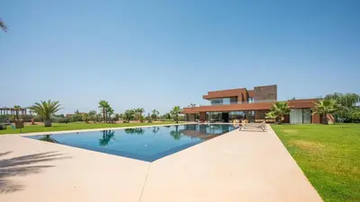 a swimming pool in front of a house at Villa Luxe Padel in Marrakech