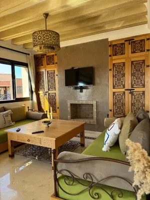 a living room with a couch and a table at Cosy Appartement Avec Piscine, Terrain tennis et loisirs in Marrakech