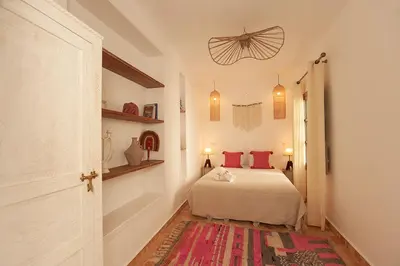 a bedroom with a bed with red pillows on it at Riad Deva Lina in Marrakech