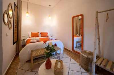 a bedroom with a bed and a mirror at Riad Le Soleil de Bahia in Marrakech