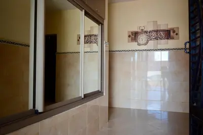 a bathroom with a shower and a large mirror at Gold Holidays 02 in Marrakech