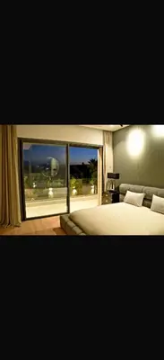 a bedroom with a bed and a large window at Villa coco in Marrakech