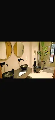 a bathroom with two sinks and two mirrors at Villa coco in Marrakech