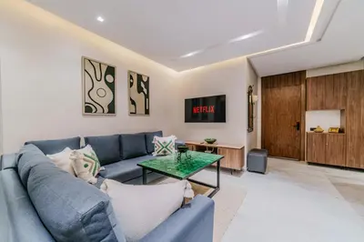 a living room with a blue couch and a table at Charming Apartment in Hyper Center Modernity in Marrakech