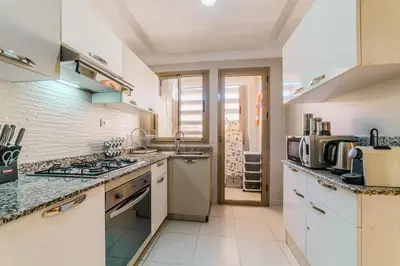 a kitchen with white counters and a stove top oven at Coralia - Cozy Apartment - Secure residence - Pool in Marrakech