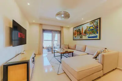 a living room with a couch and a tv at Coralia - Cozy Apartment - Secure residence - Pool in Marrakech