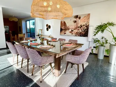 a dining room with a large wooden table and chairs at Palais Celeste in Marrakech