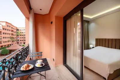 a balcony with a bed and a table with a plate of food at Résidence Babylone Y - 2 Bedrooms Appartement in Marrakech
