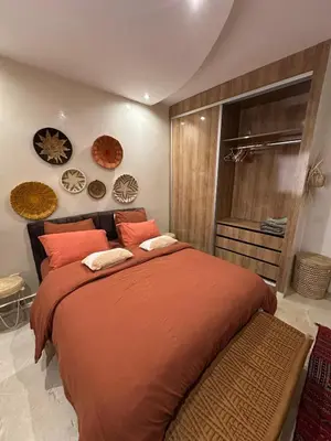 a bedroom with a large bed with orange pillows at J40 super bien équipé a L'HIVERNAGE in Marrakech