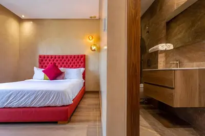 a bedroom with a bed with a red headboard and a sink at Villa located at Argan Golf Resort Prestigia in Marrakech