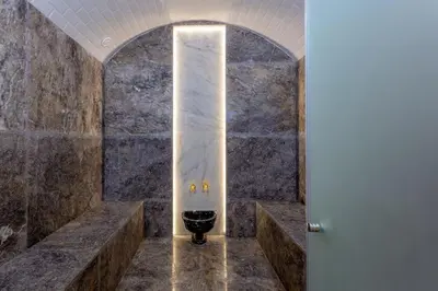a bathroom with a toilet in a stone wall at Villa located at Argan Golf Resort Prestigia in Marrakech