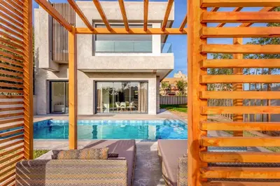 a house with a swimming pool and a wooden fence at Villa located at Argan Golf Resort Prestigia in Marrakech